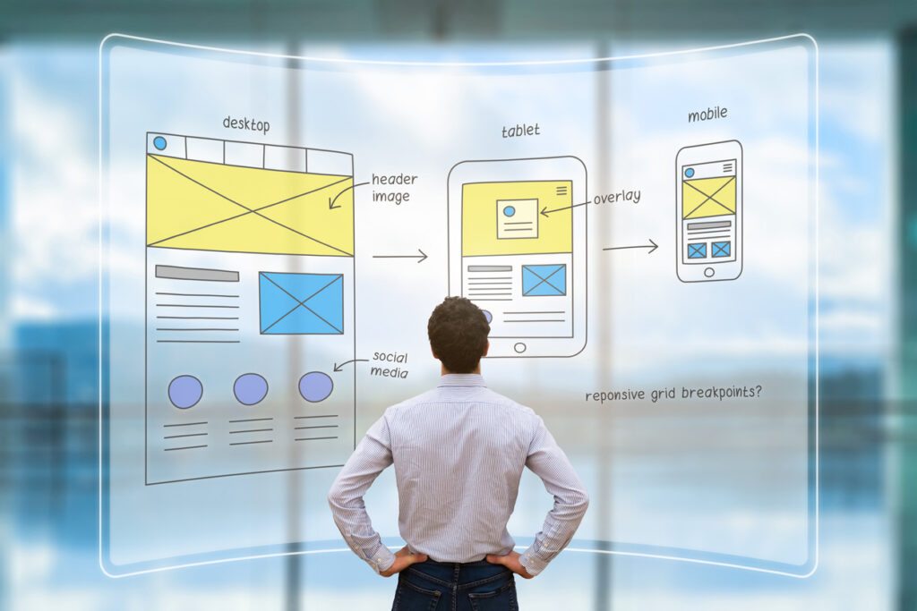 Website development UI/UX front end designer reviewing sketched wireframe layout design mockup for responsive web content with AR screen