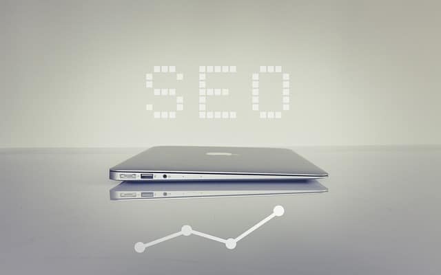 A minimalistic laptop setup with "SEO" displayed above, representing digital growth and strategy.